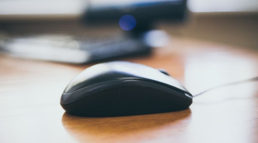 A wired mouse sitting on a desk.